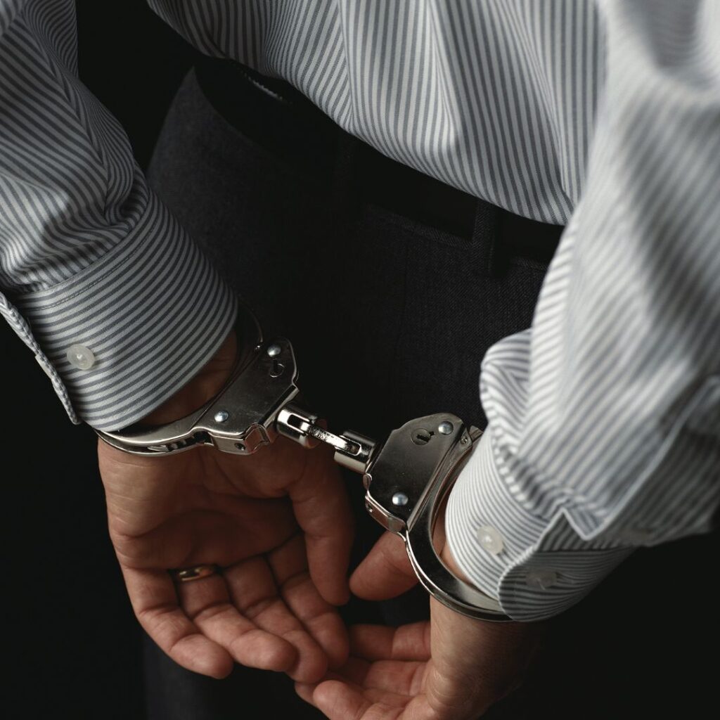 person wearing suit in handcuffs